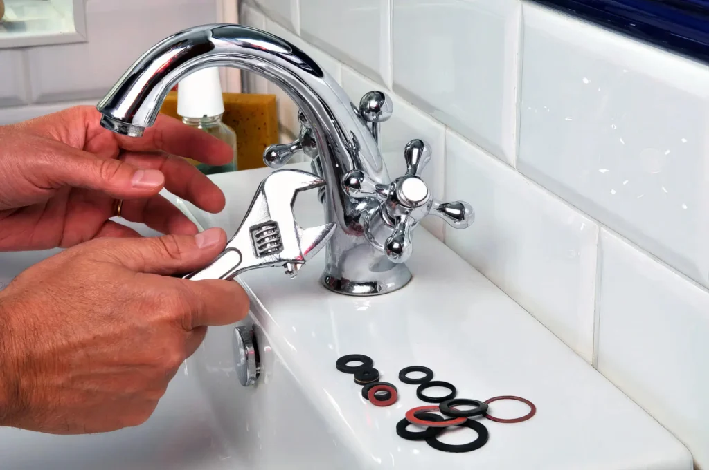 Plumber performing maintenance on a bathroom faucet in Cheltenham