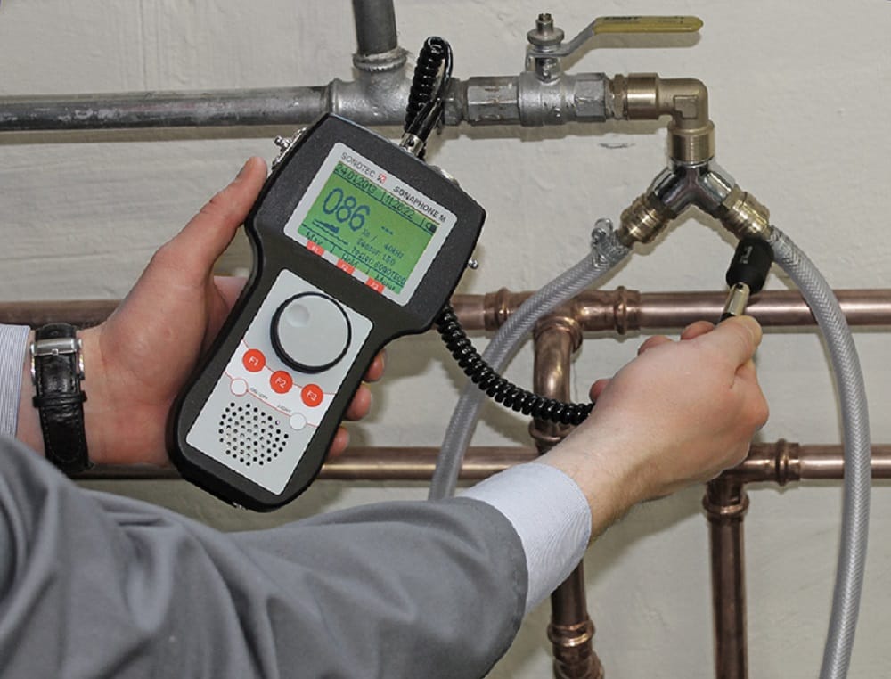 Plumber testing pipes with electronic leak detection equipment in Cheltenham