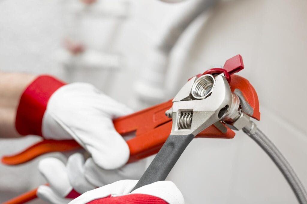 Plumber holding pipe wrenches for an emergency repair in Cheltenham