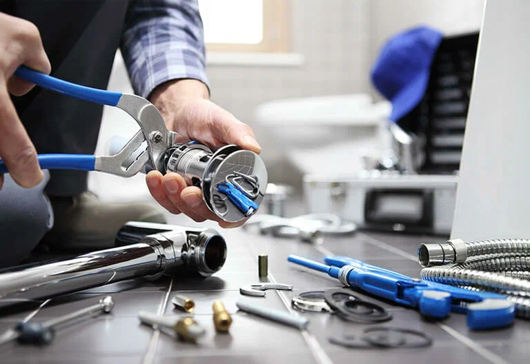 Technician repairing a plumbing fixture with professional tools in Cheltenham
