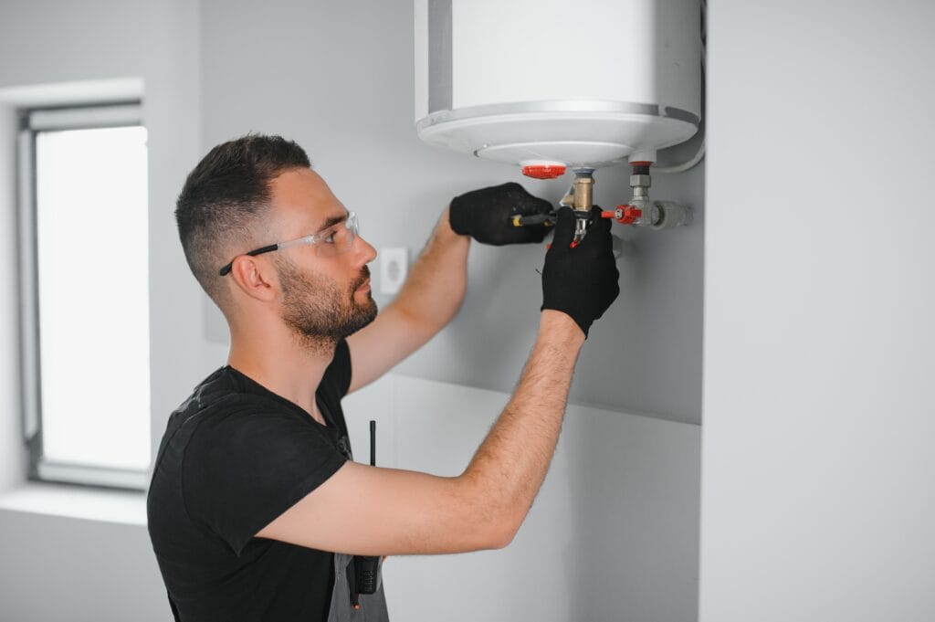 Technician performing water heater maintenance in Cheltenham