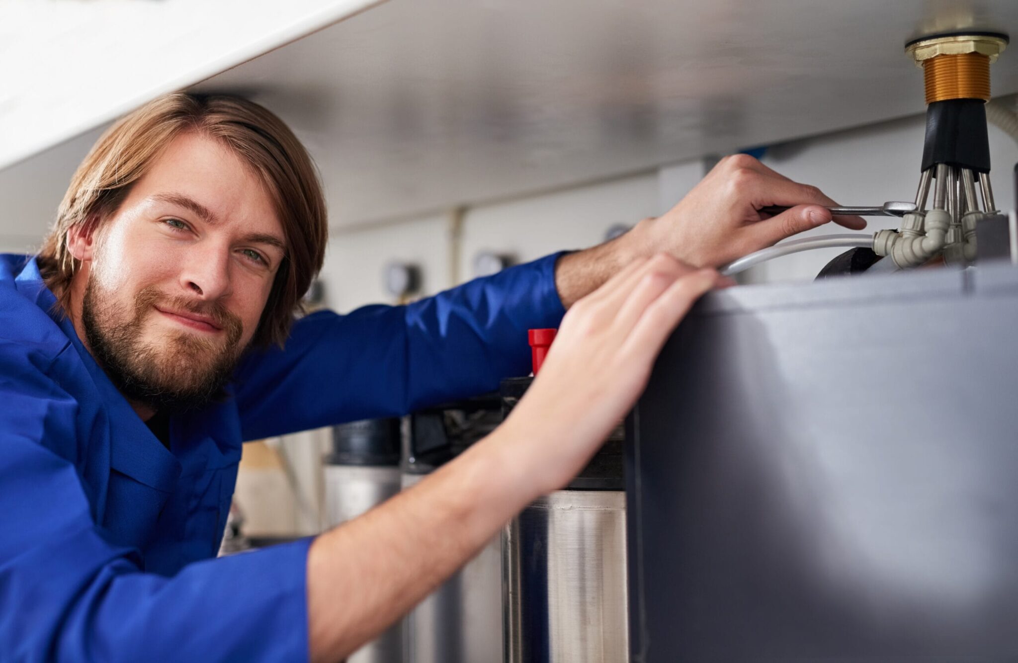 Technician servicing a residential water heater tank in Cheltenham