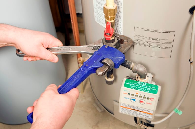 Plumber repairing a water heater valve in Cheltenham
